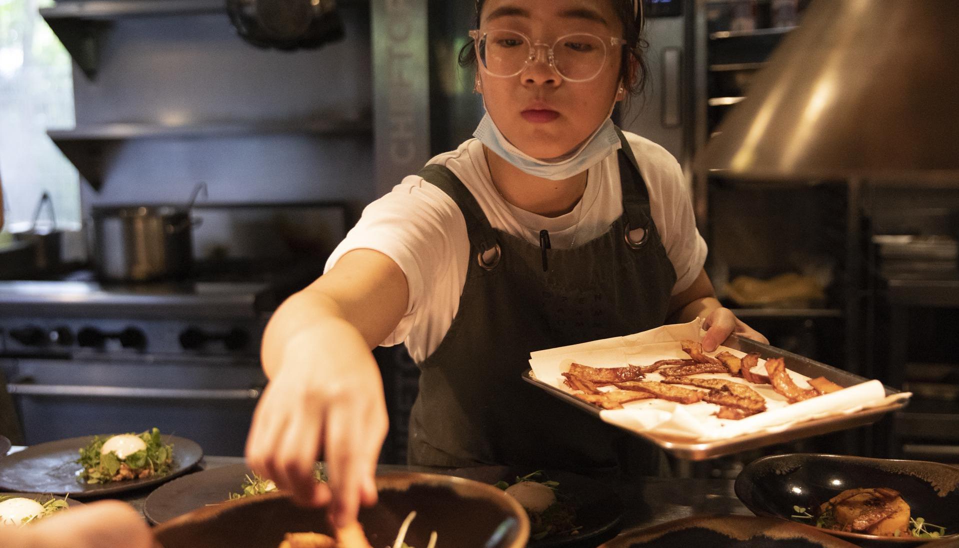 Una cocinera prepara plato creado por el chef Oliver Juntas en Singapur