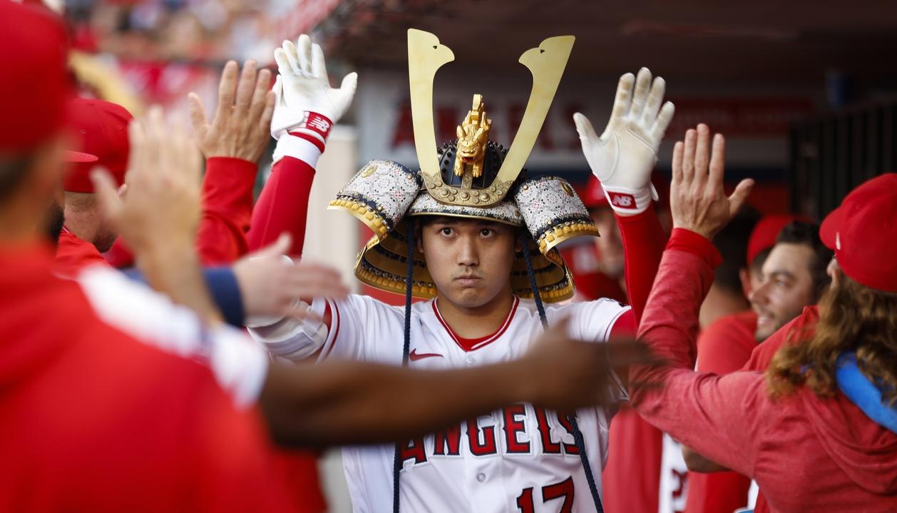 Shohei Ohtani es felicitado por sus compañeros en el dugout.