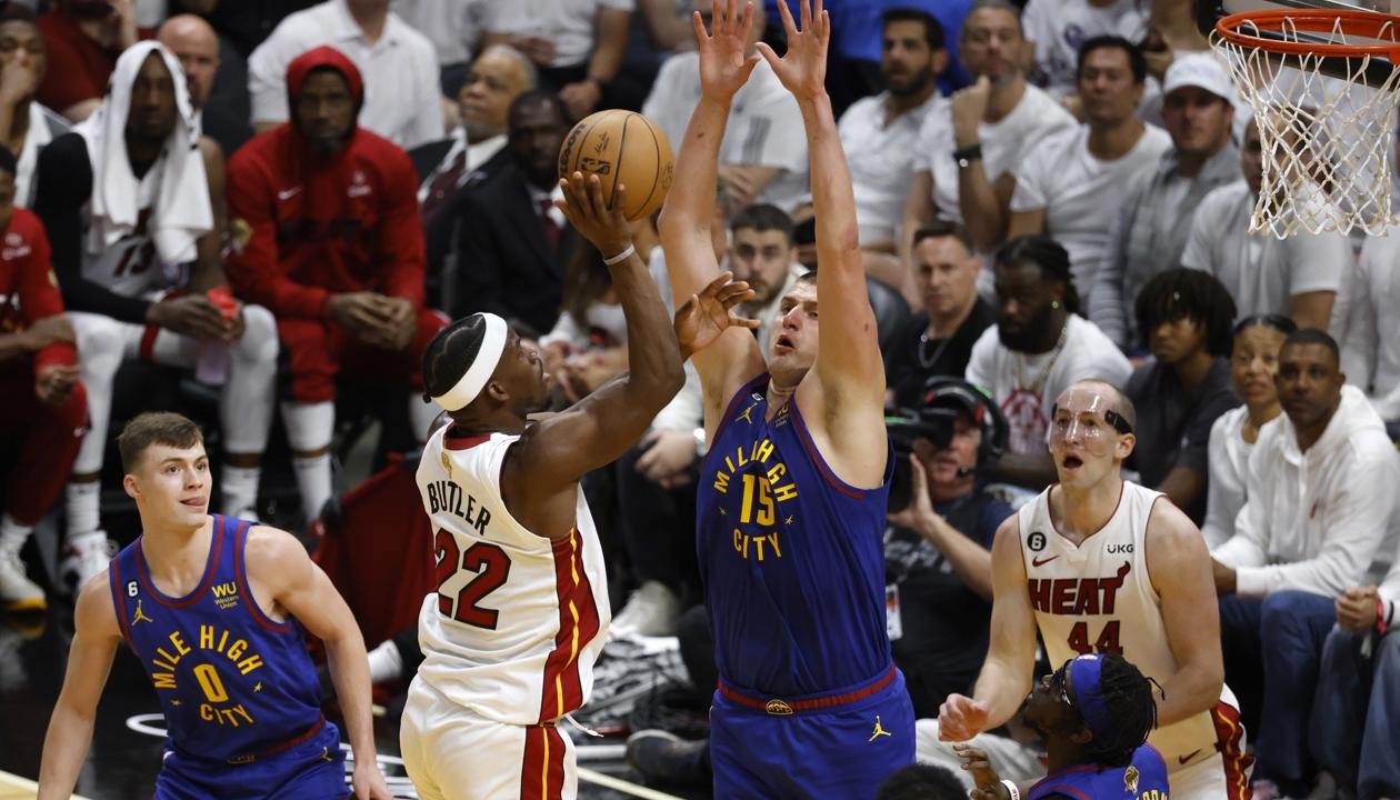 Nikola Jokic intenta bloquear el lanzamiento de Jimmy Butler.