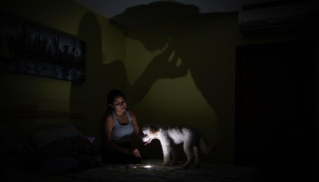 Una mujer usa la lámpara de su celular tras la falta de energía en Venezuela. 