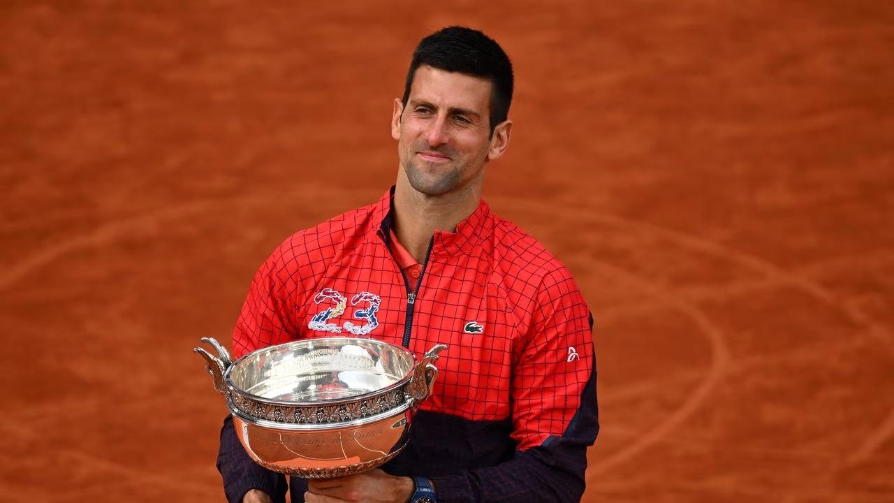 Novak Djokovic besa el trofeo que lo convierte en el más ganador de torneos de Grand Slam. 
