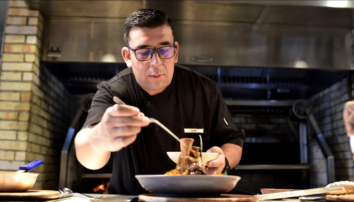Edwin Marín Palma en pleno emplatado del osobuco de ternera con arroz caldoso de guandú y champiñones
