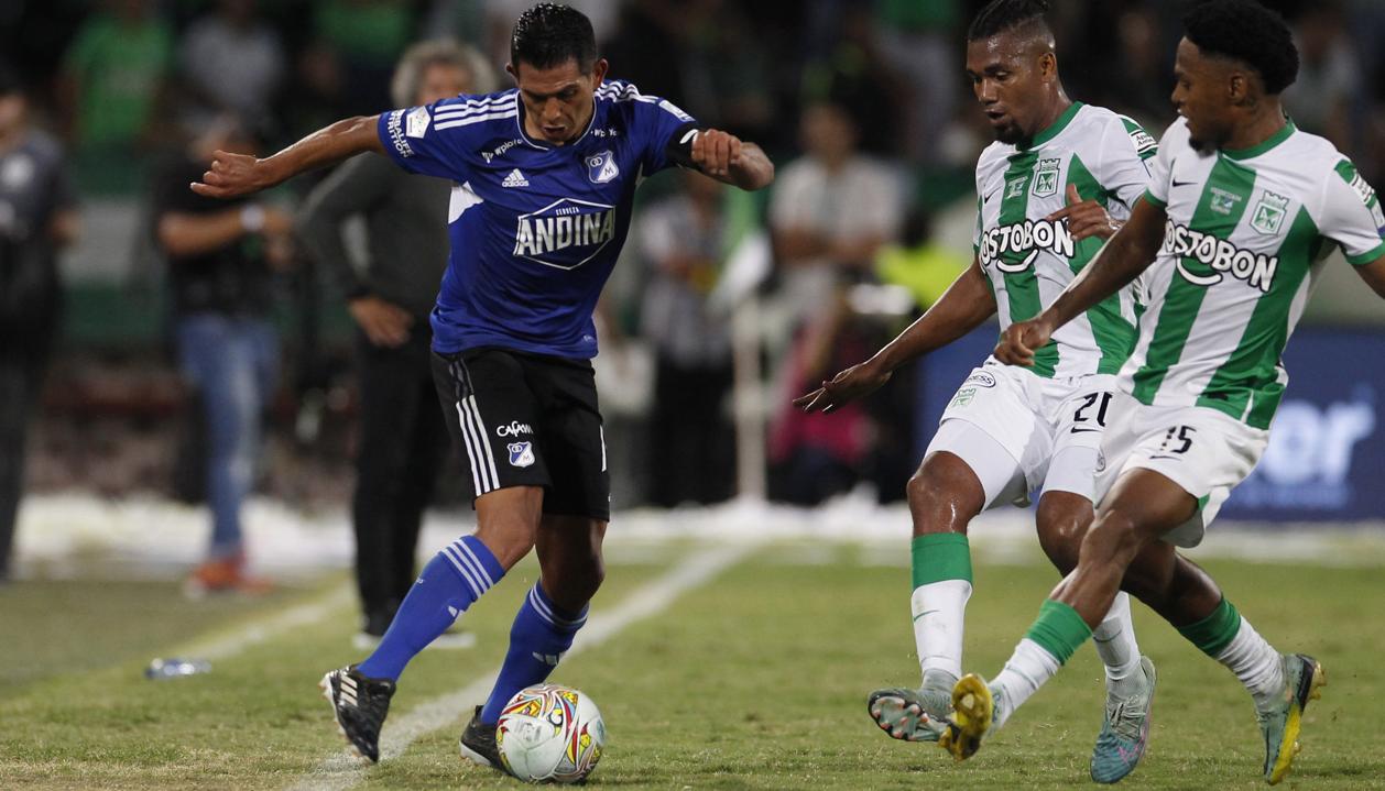 David Macalister Silva encara dos rivales de Nacional durante el partido en Medellín. 