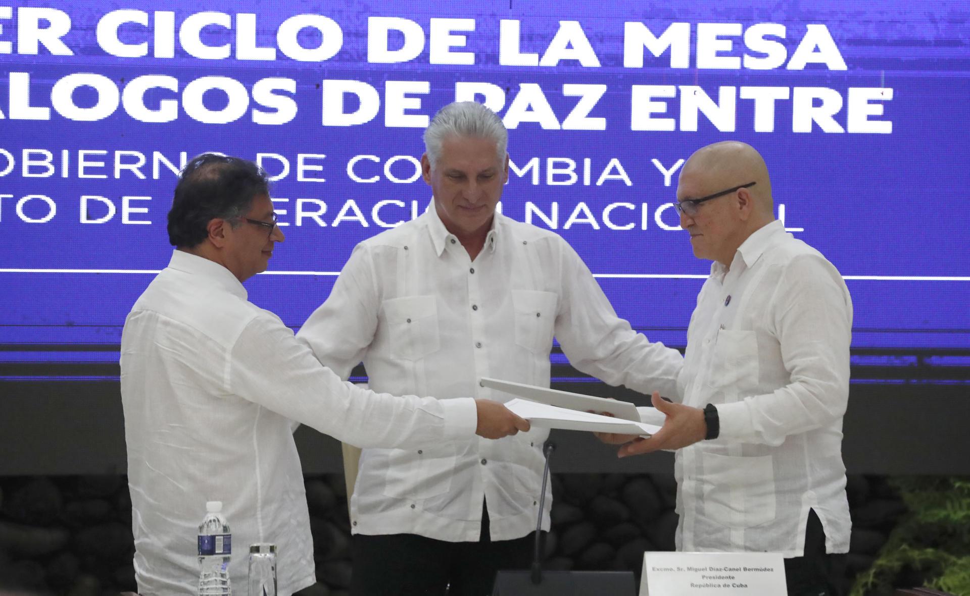 El presidente Gustavo Petro, mientras entrega documentos al jefe máximo de la guerrilla del ELN, Antonio García.  