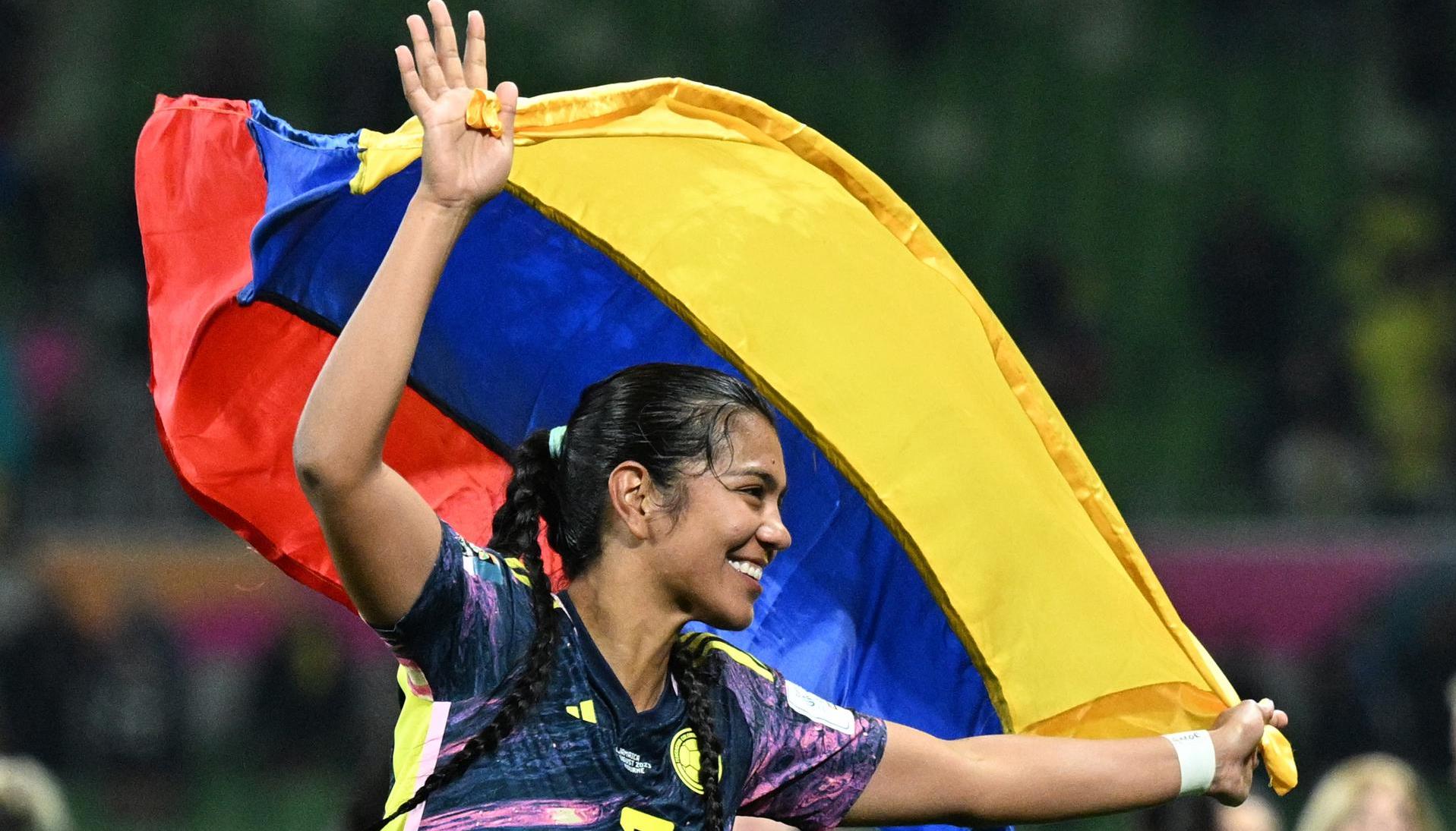 La jugadora colombiana Daniela Arias celebra, con la bandera de su país este martes luego de pasar a cuartos de final