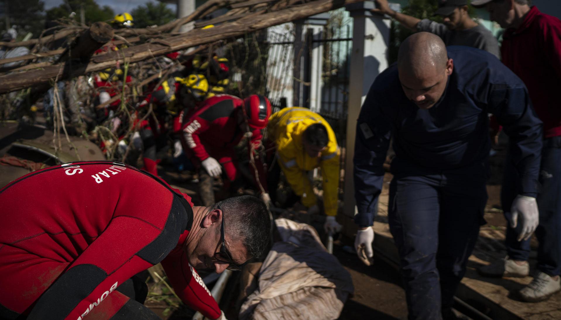 Bomberos retiran el cuerpo de una persona tras las inundaciones. 
