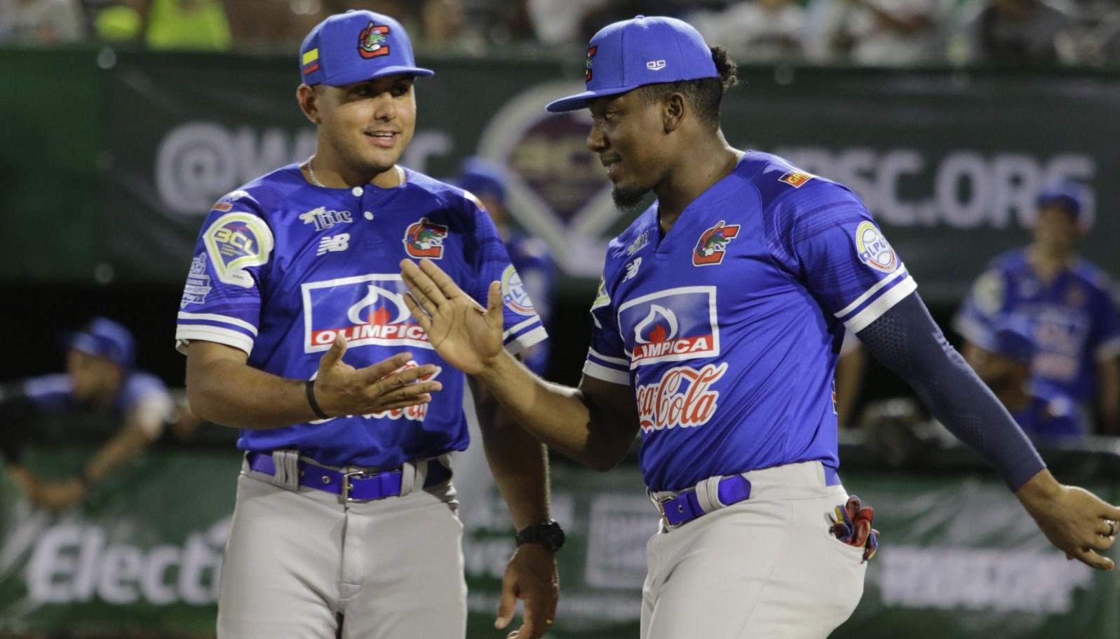 Jesús Marriaga, el pelotero más destacado de Caimanes en el juego, recibe el saludo del mánager Carlos Vidal.