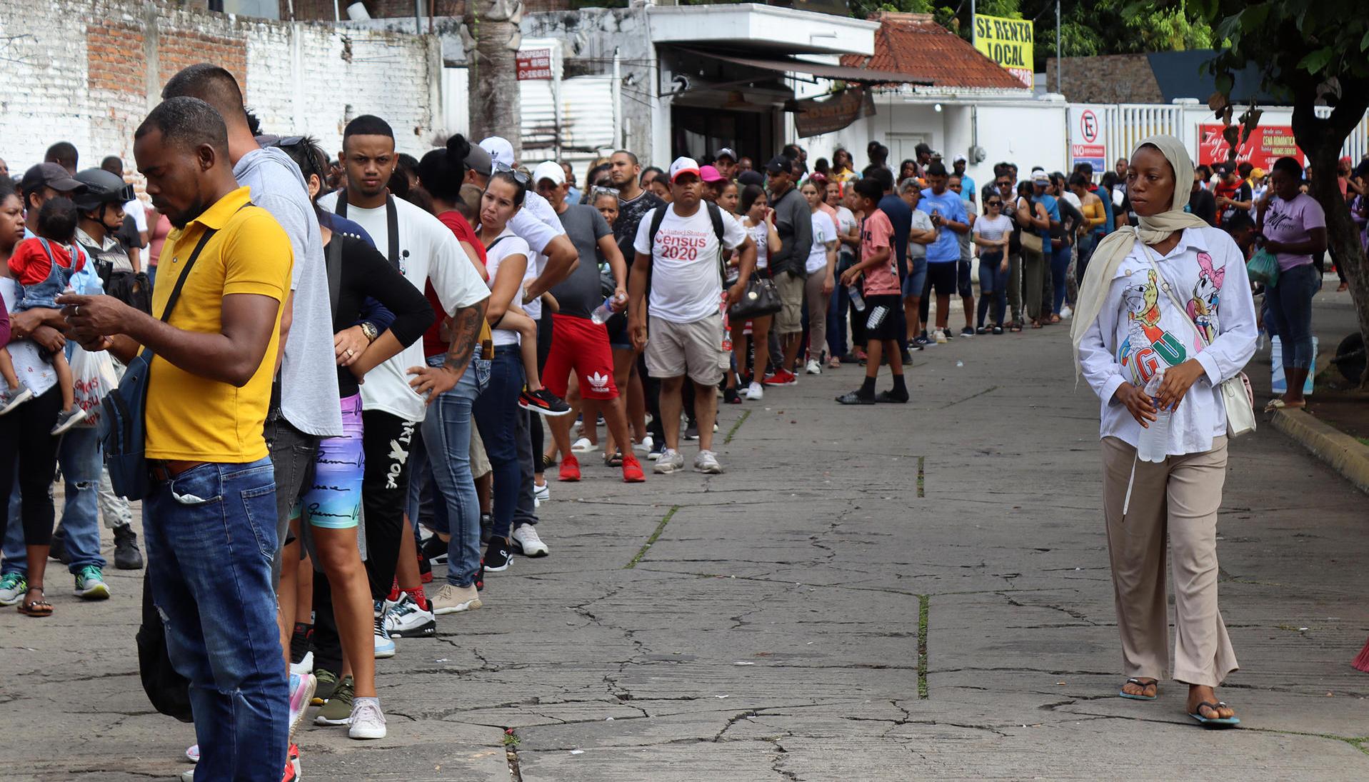 Migrantes hacen fila en espera de regularizar su documentación en el municipio de Tapachula, en el estado de Chiapas
