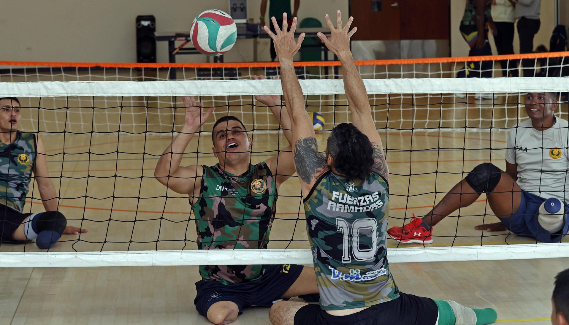 El veterano del Ejército Edward Guerrero (2-i) participa en una práctica de voleibol.