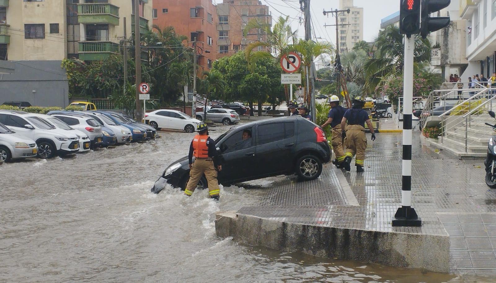 Dos vehículos atrapados en arroyo de la 85 durante el aguacero de este jueves.