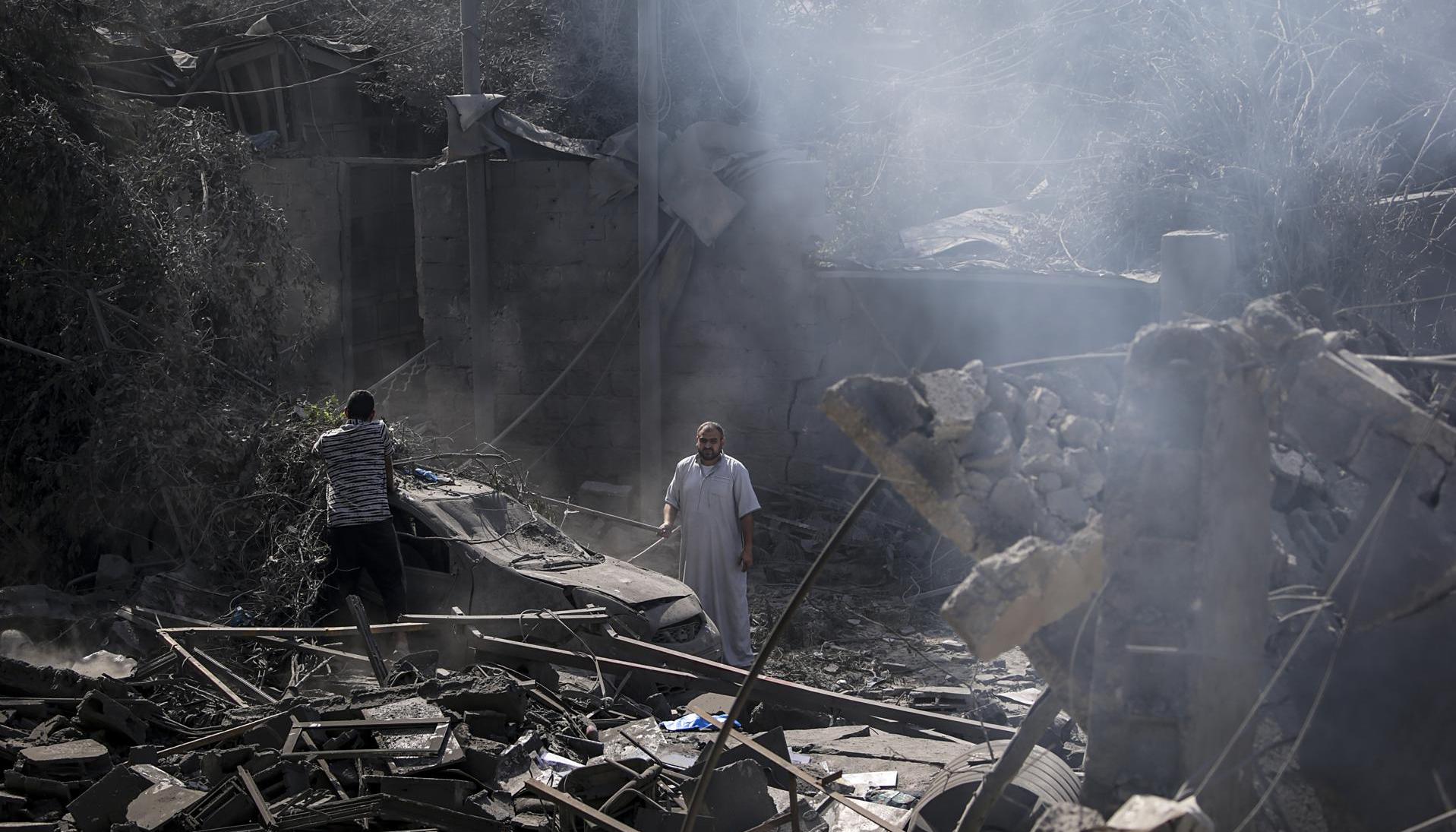 Dos palestinos miran los escombros de la casa destruida de la familia Al Shawa, en Gaza.
