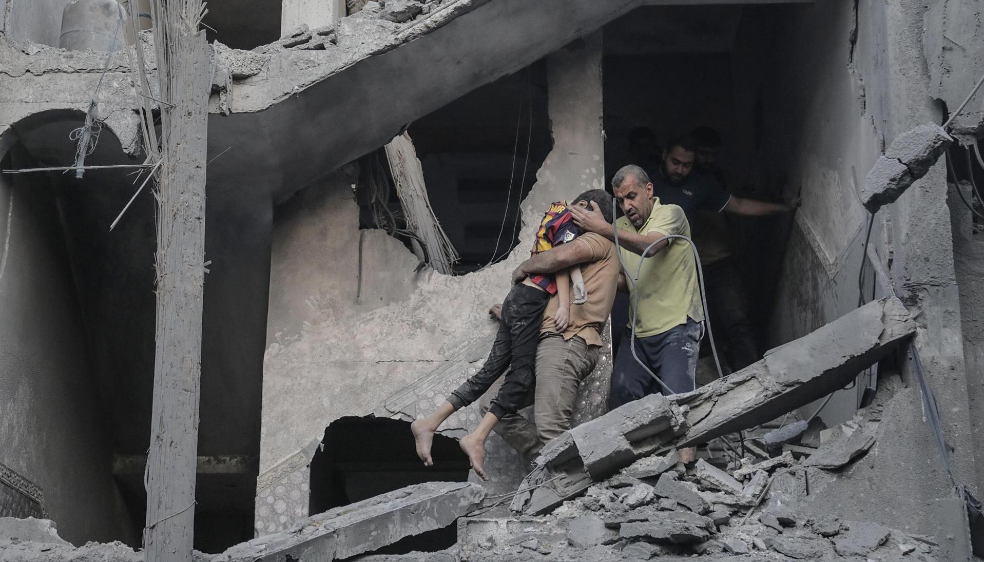 Un niño es rescatado de los escombros de un edificio residencial derribado.