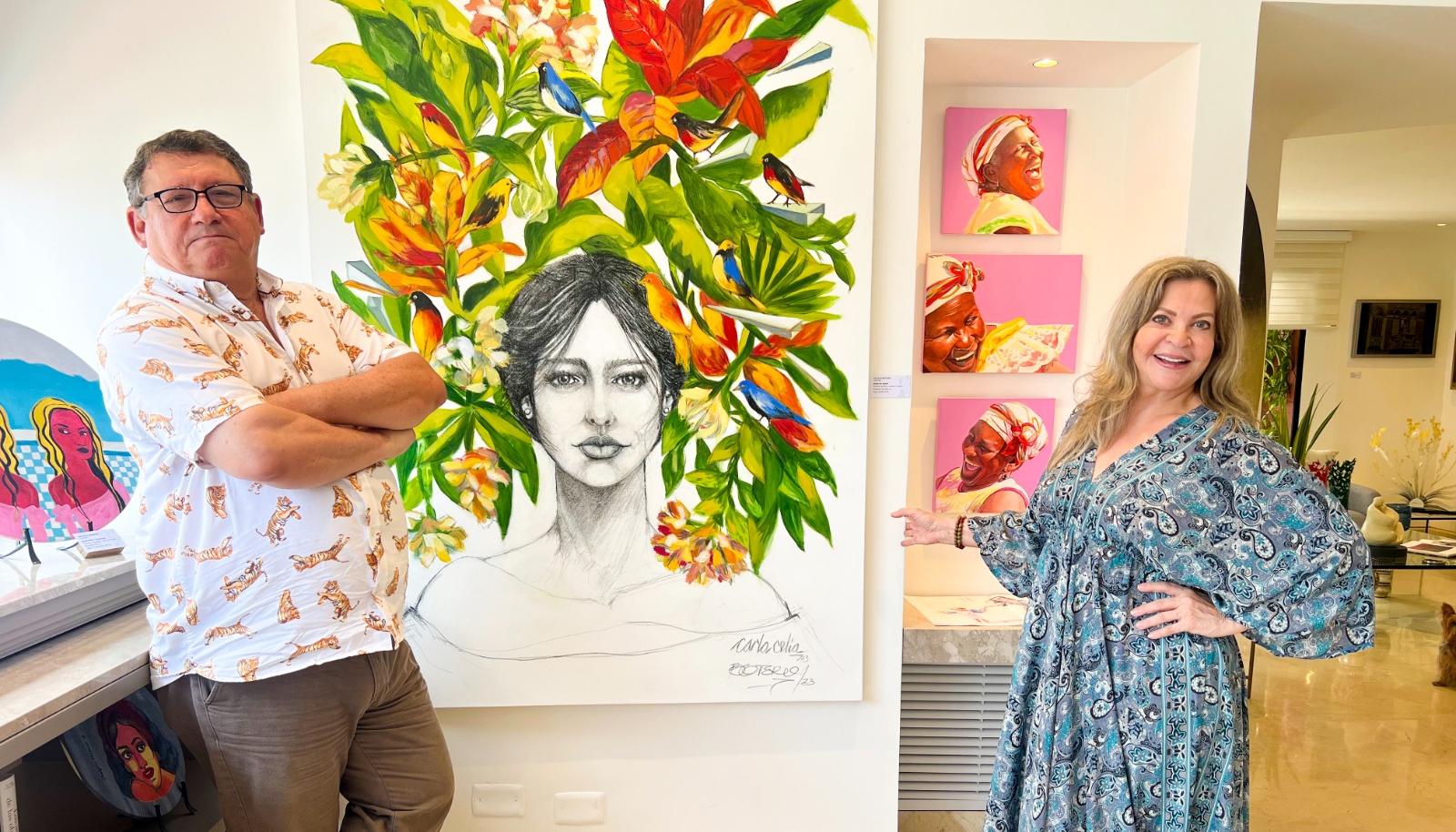 Miguel Iriarte, curador de 'Musa Galería de Arte', y la directora Cielo Támara con el fondo de una obra de Carla Celia y Joaquín Botero