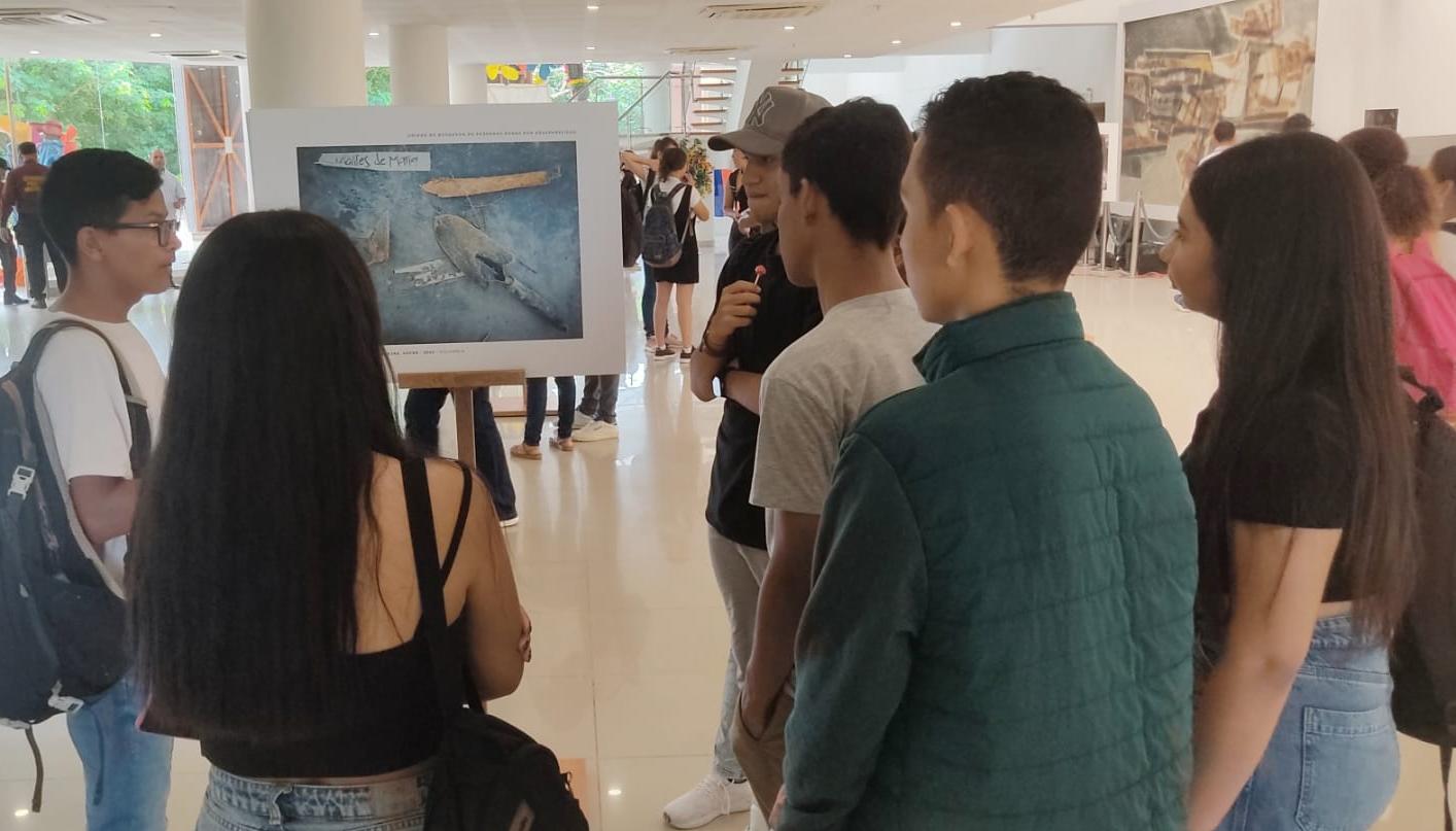 Un grupo de jóvenes viendo una de las obras exhibidas.
