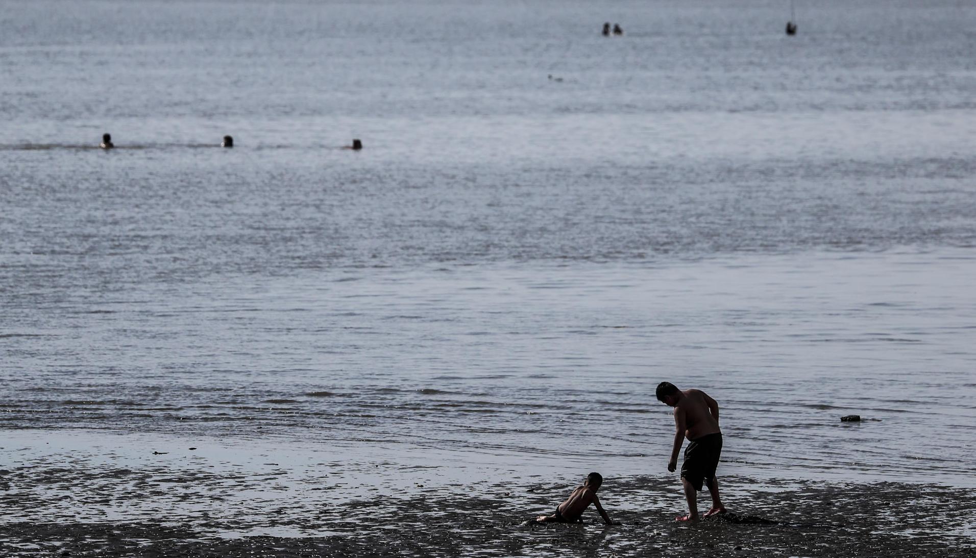 Un hombre y un niño se bañan en el Río de la Plata, en una fotografía de archivo