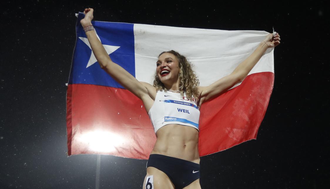 Martina Weil exhibe la bandera chilena tras ganar el oro en los 400 metros.