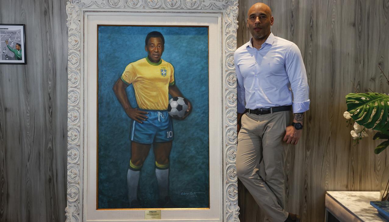Edinho junto a un retrato de su padre en el Museo Pelé.