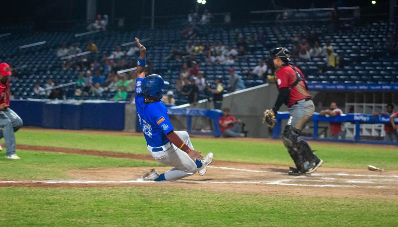 Carlos Arroyo anota la quinta carrera de Caimanes, en el cuarto inning.