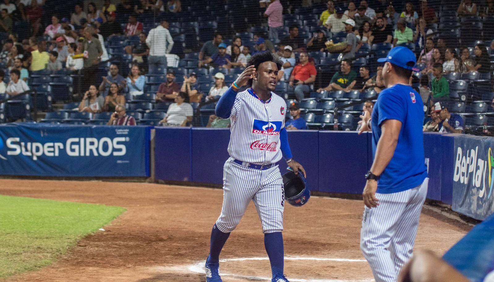 Dilson Herrera es felicitado por su mánager José Mosquera tras batear un jonrón de tres carreras en el segundo juego. 