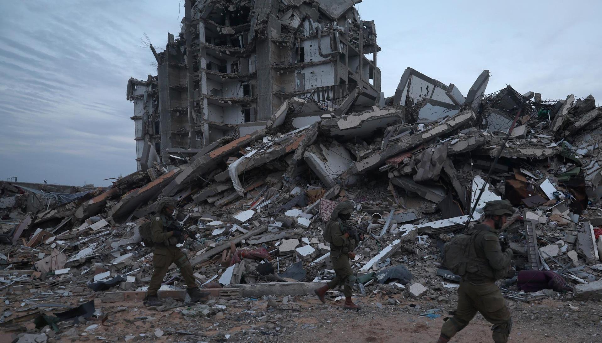 Foto de archivo de unos soldados israelíes caminando entre los escombros de edificios destruidos en la localidad palestina de Beit Lahia
