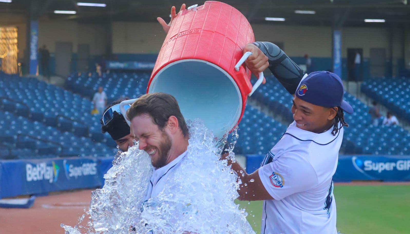 Luke Brown es bañado por su compañero de equipo Félix Reyes.