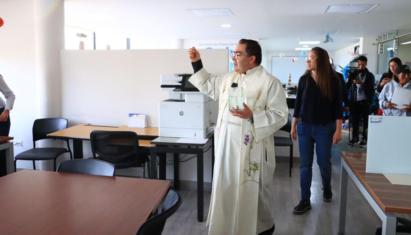 Un sacerdote rocía agua bendita en el despacho del nuevo alcalde de Tunja.