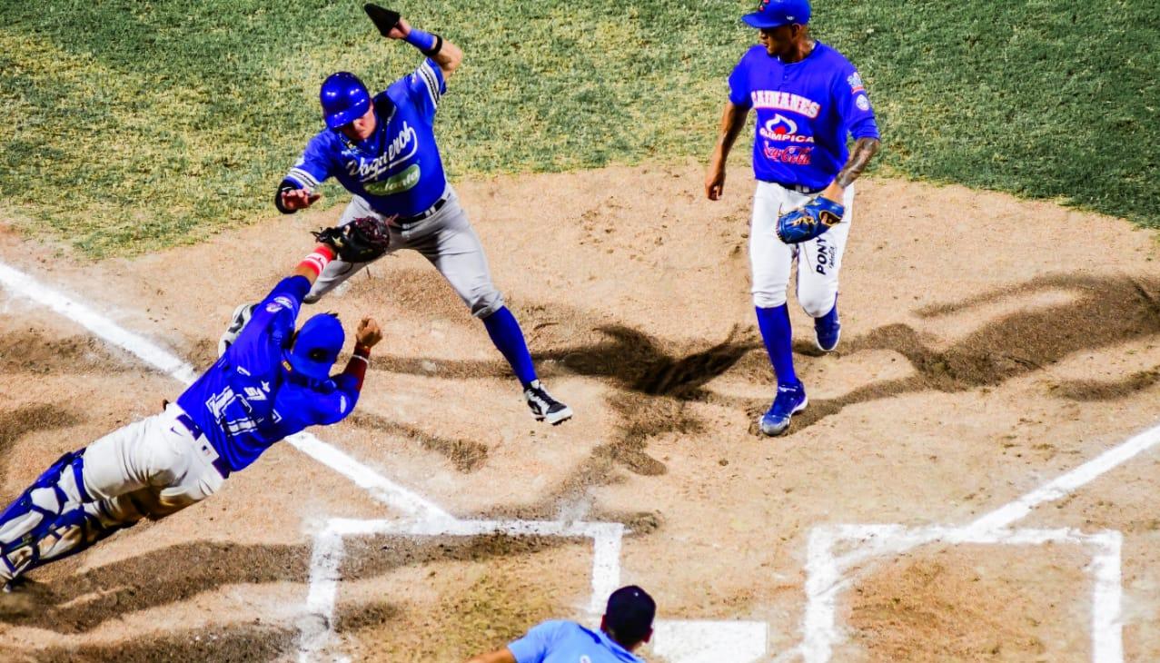 Bryan Flete evita ser tocado por el receptor de Caimanes, Jair Camargo, y anota la tercera carrera de Vaqueros.