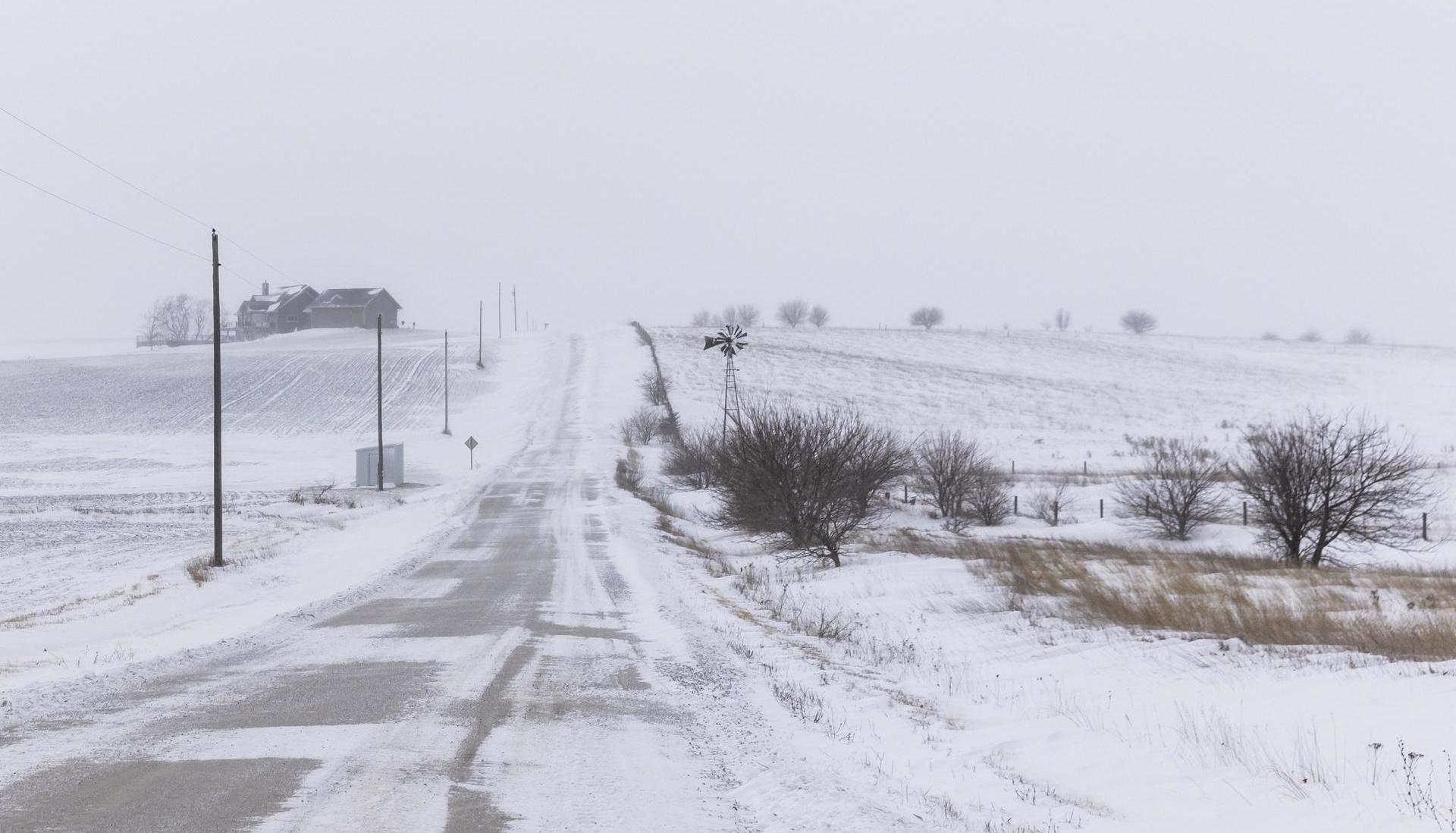 Vista de una calle cubierta con nieve tras una tormenta, en Adair County, Iowa