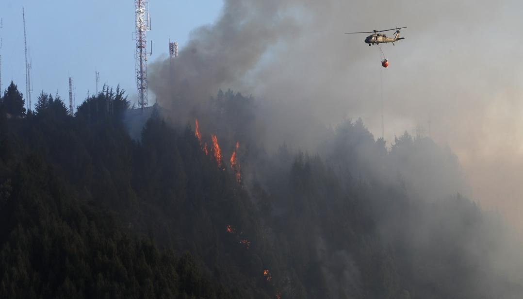 Un helicóptero combate un incendio forestal en el cerro El Cable, en Bogotá.