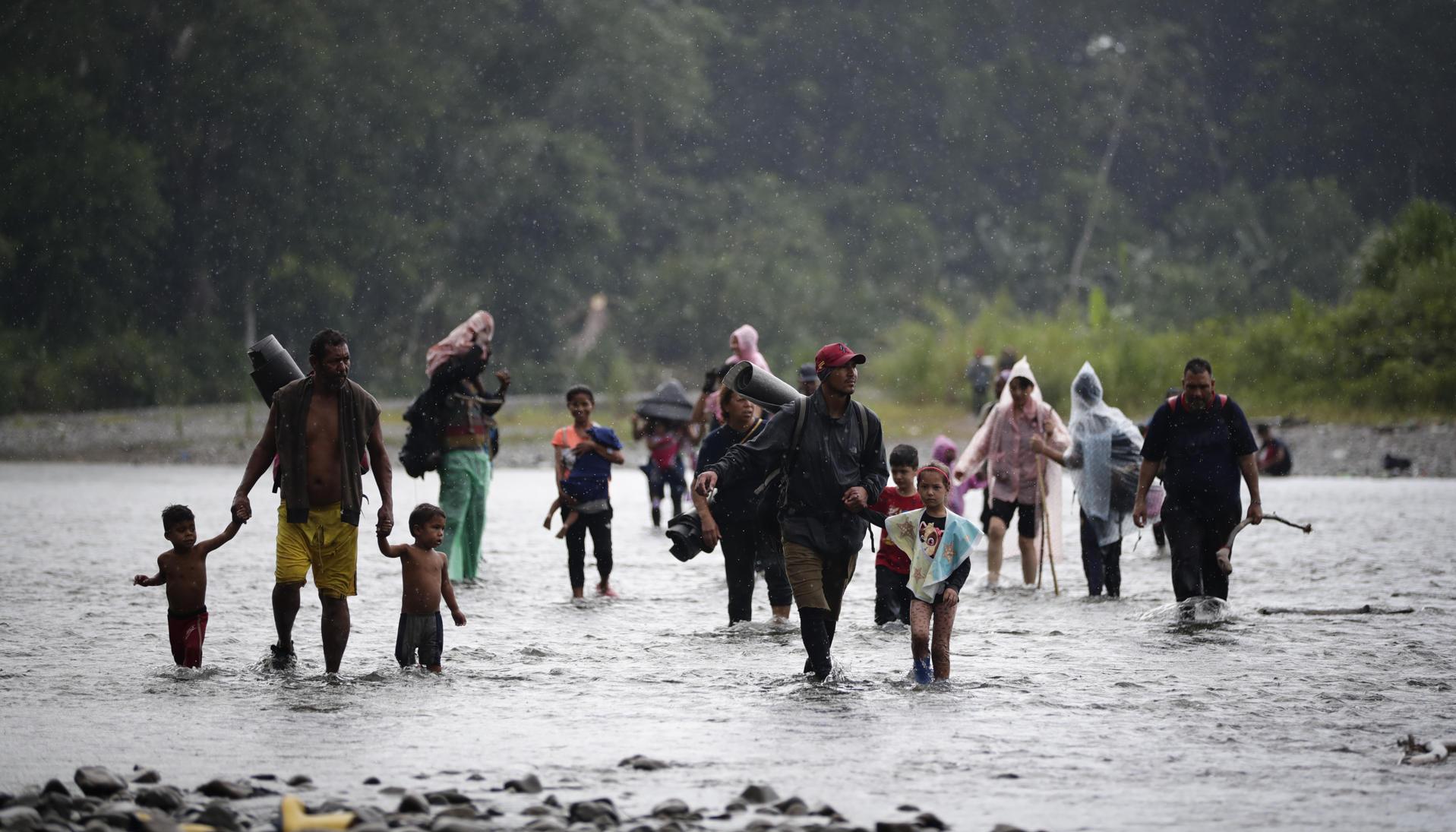 Migrantes cruzan el río Turquesa, en Darién (Panamá).