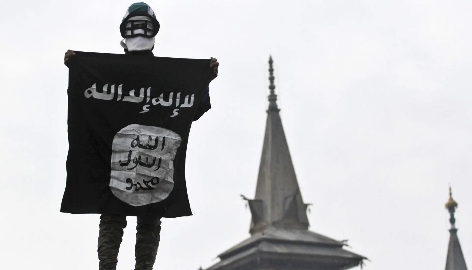 Hombre sostiene la bandera del Estado Islámico.