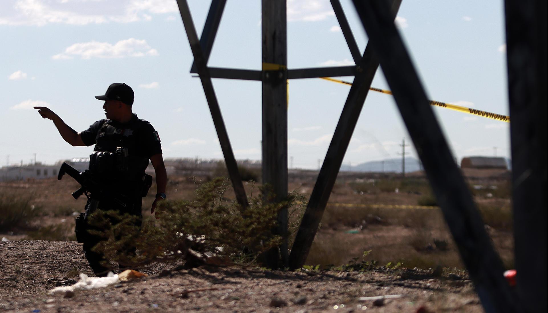 Un policía monta guardia en la fosa común hallada en zona rural de Ciudad Juárez