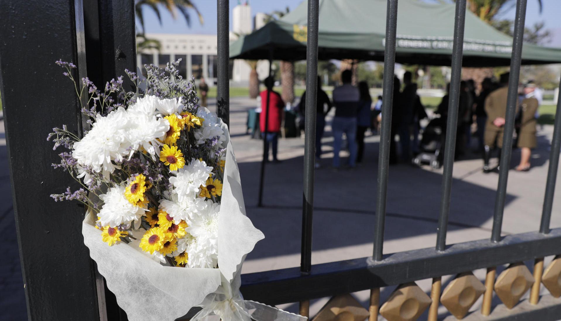 Personas llegan a firmar un libro de condolencias, en la Escuela de Carabineros, este sábado en Santiago, tras el asesinato de tres policías 