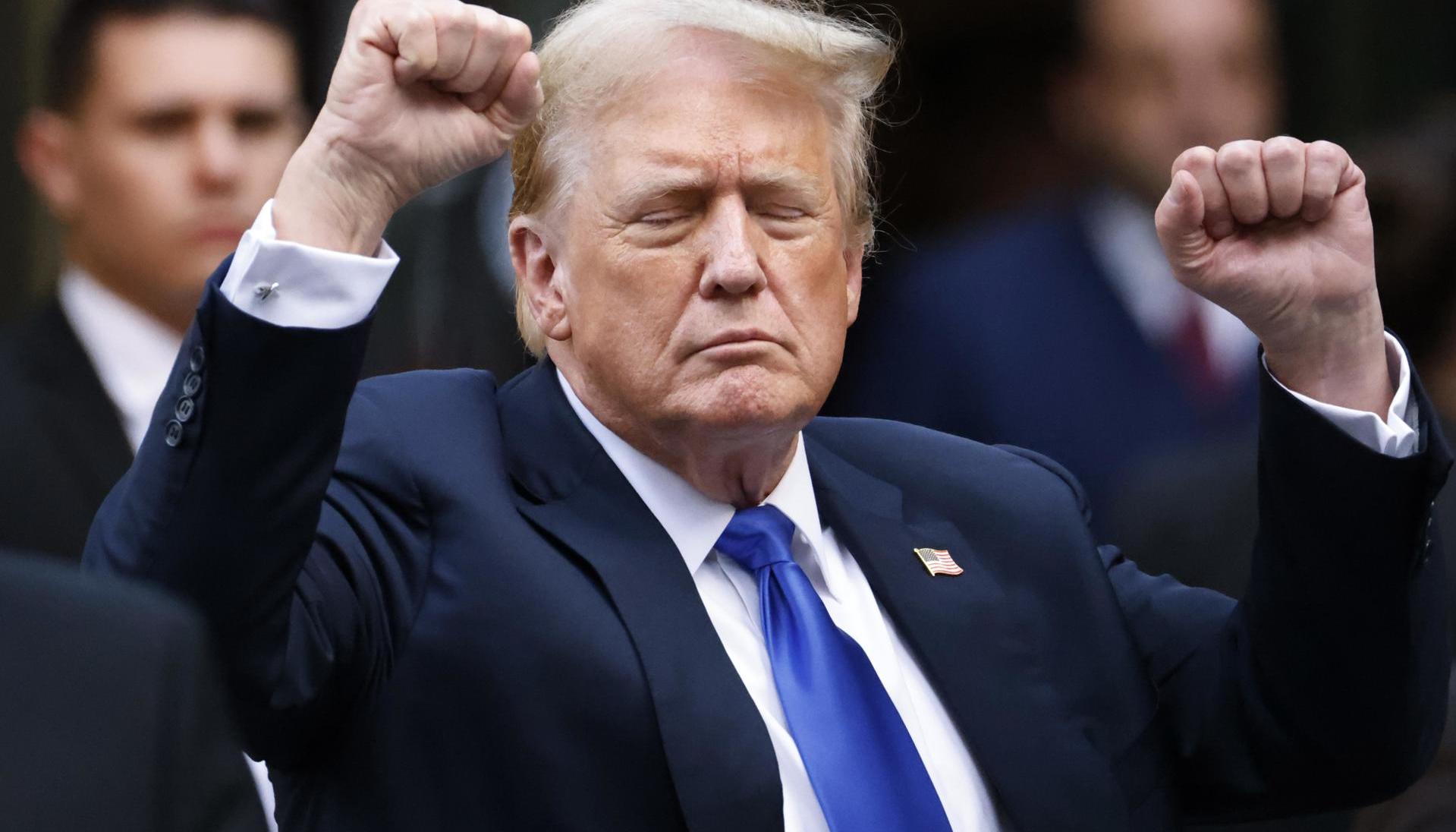 Donald Trump hace gestos a los medios de comunicación y a la multitud afuera de la Torre Trump. 