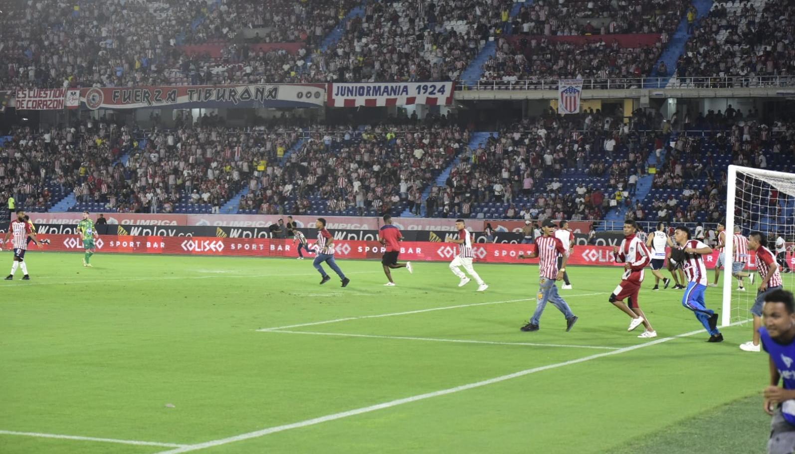 Hinchas invadieron la cancha tras los enfrentamientos en la tribuna sur. 