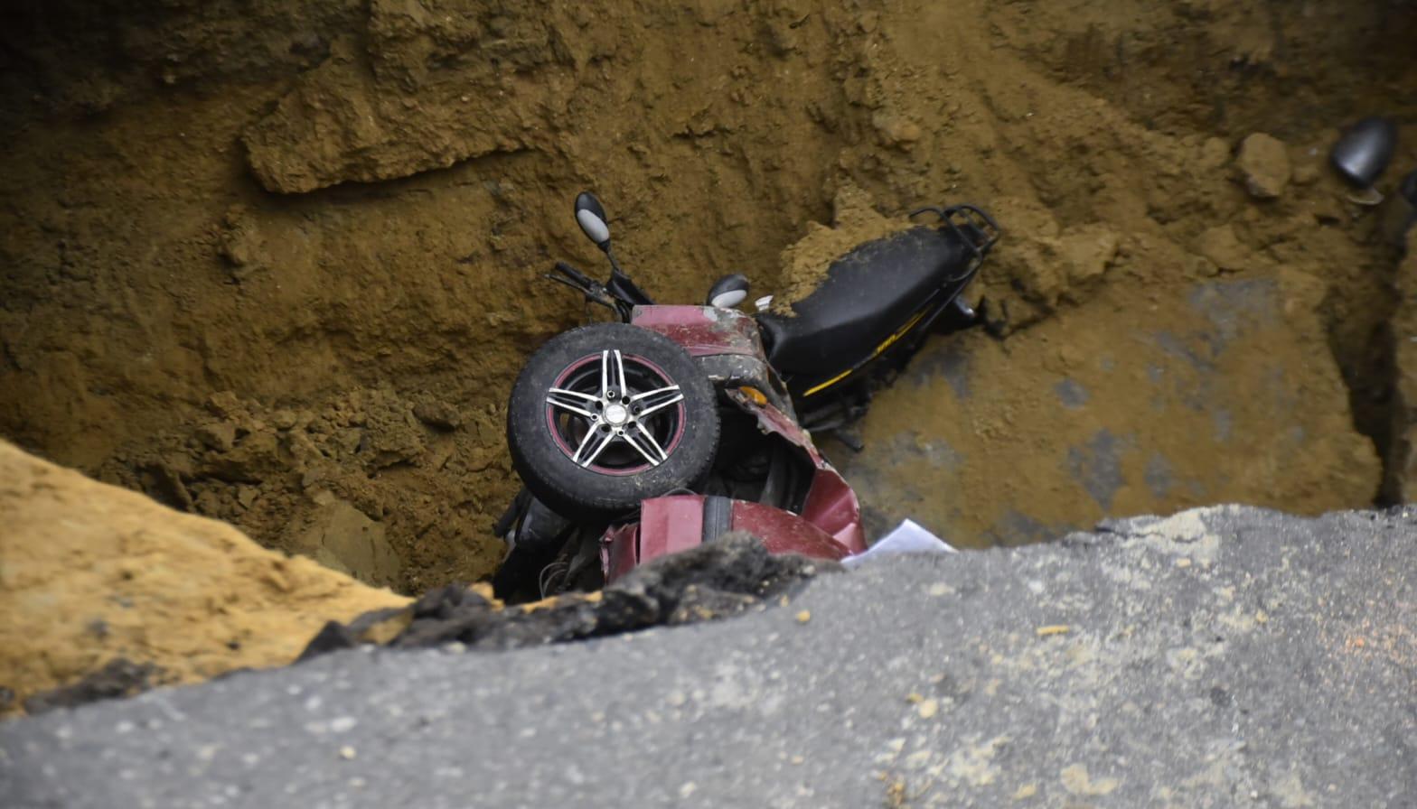 La moto y uno de los vehículos que cayeron al vacío.