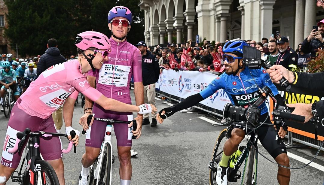 Tadej Pogacar se saluda con el colombiano Daniel Martínez antes de arrancar la tercera etapa. 
