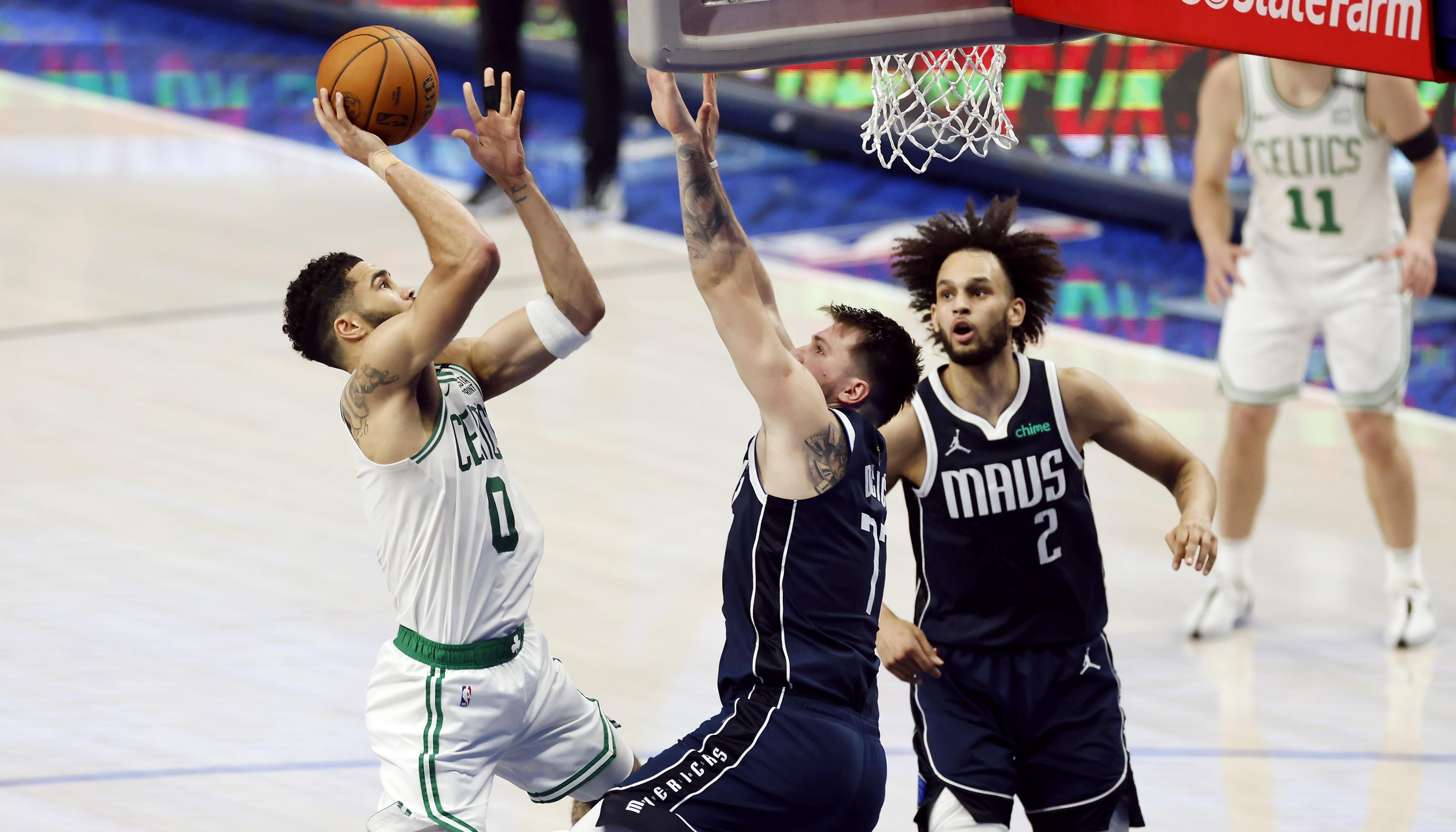 Luka Doncic intenta bloquear el lanzamiento de Jayson Tatum. 