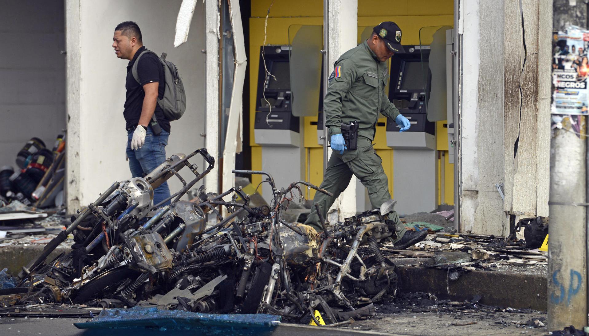 Uniformados caminan sobre los destrozos tras el atentado con motocicleta bomba en una estación de Policía en Jamundí