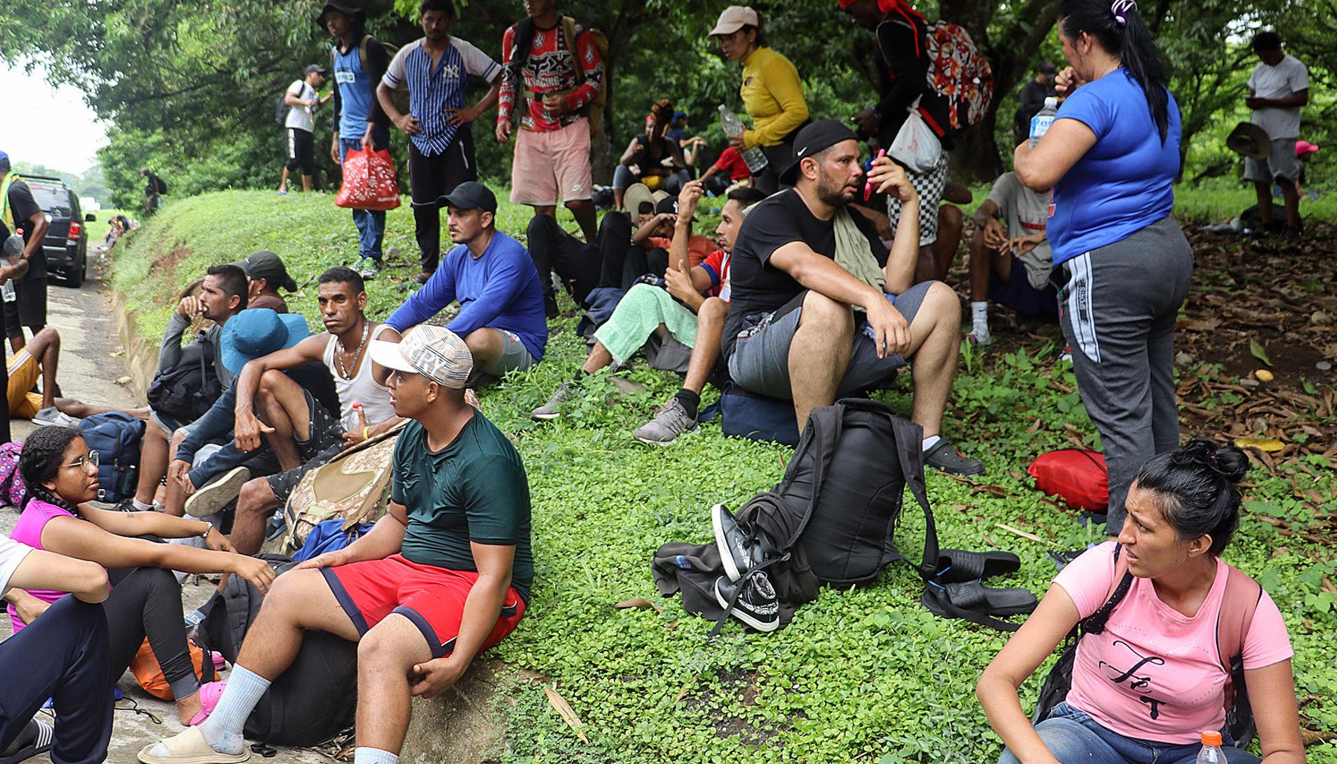 Migrantes descansan a un costado de la vía, en el municipio de Huixtla en Chiapas (México).