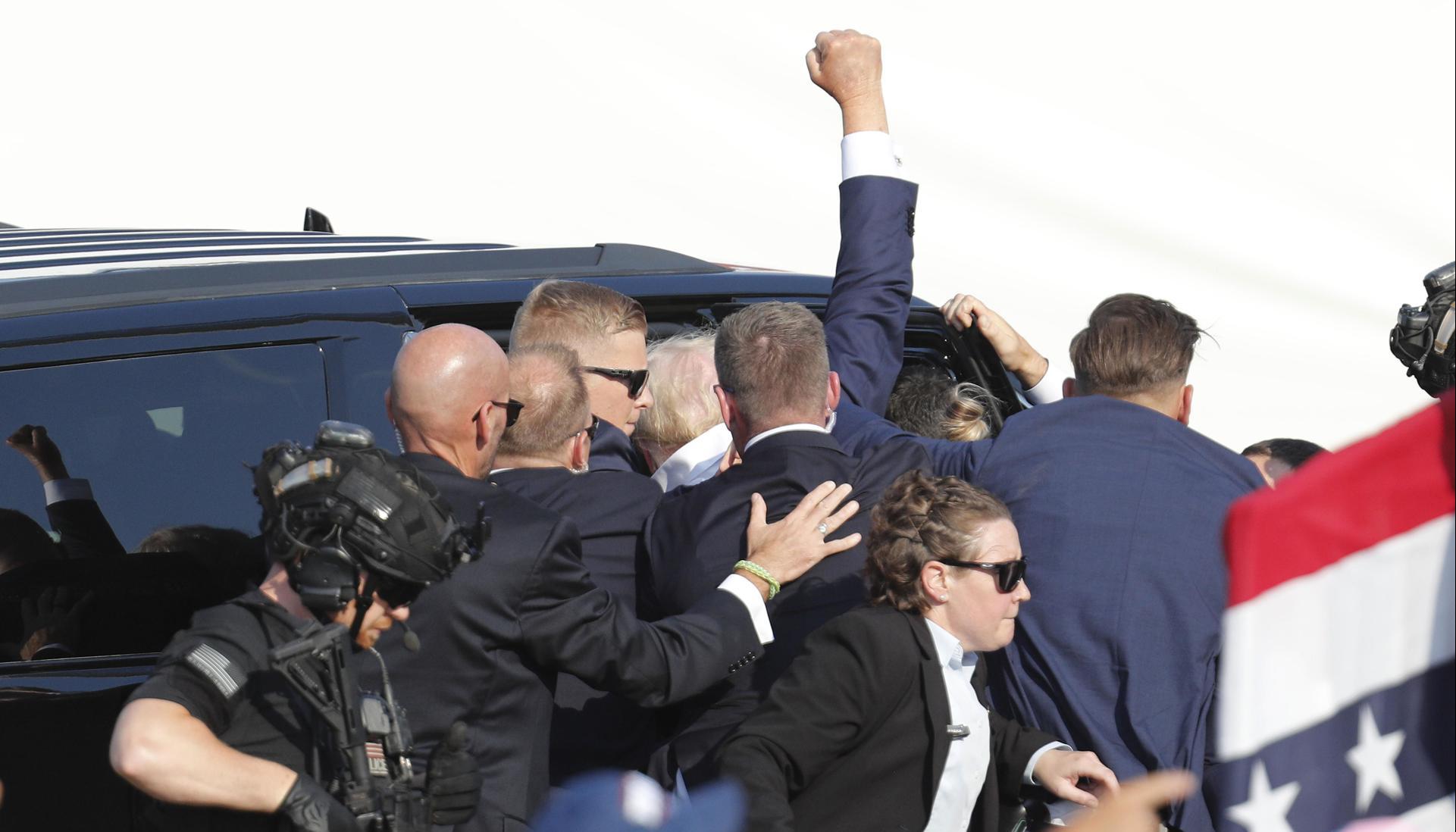 Trump cuando era evacuado del lugar donde fue impactado a bala. 