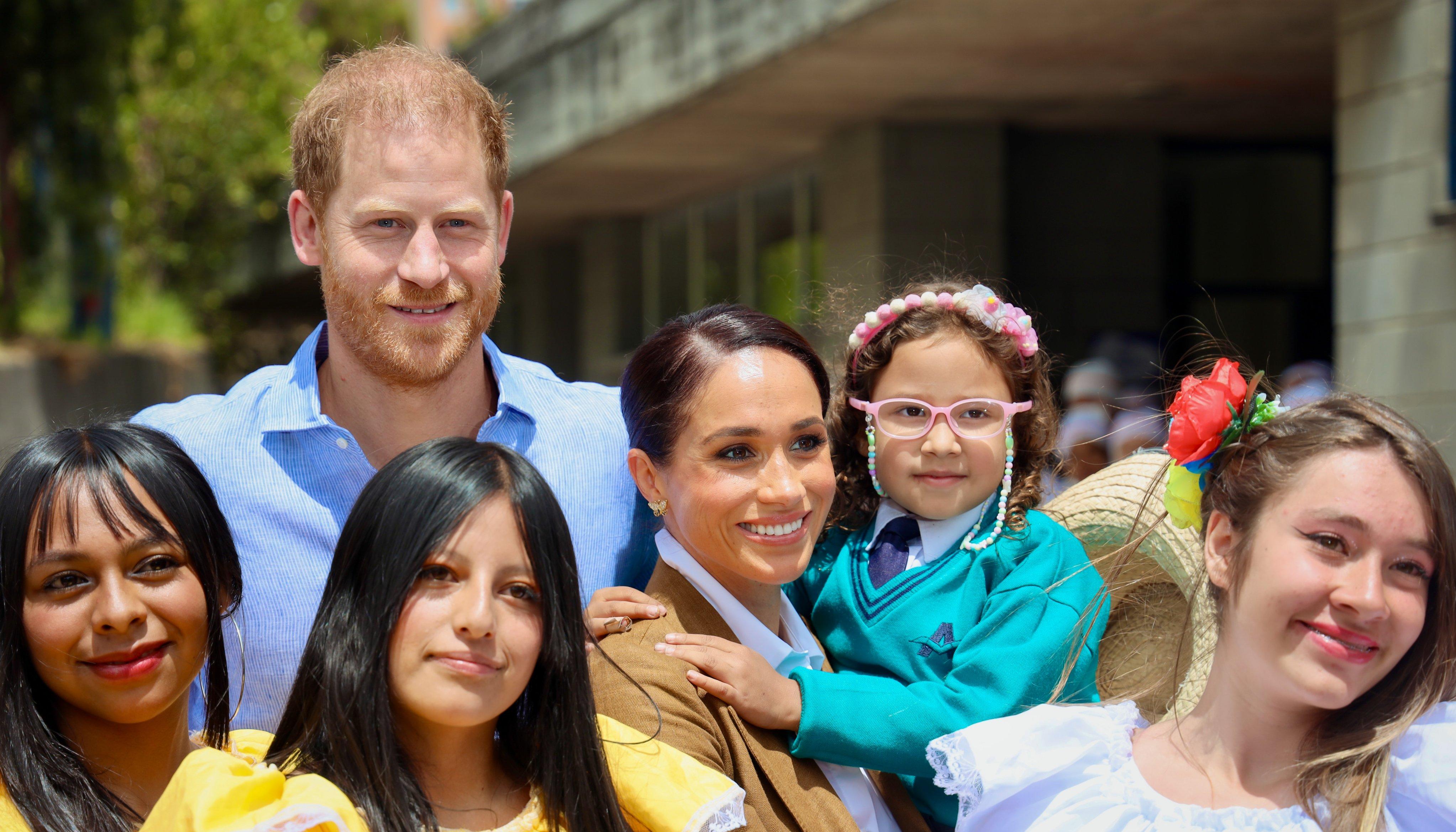 Los duques de Sussex junto con niños en un evento en Bogotá.