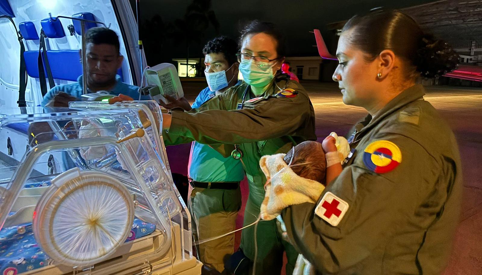 El bebé en manos de personal militar antes de ser ingresado a la aeronave medicalizada.