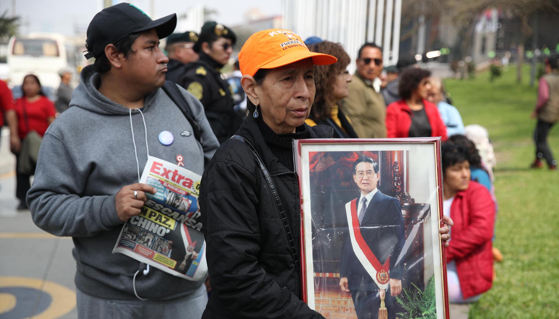 Una simpatizante del fallecido presidente de Perú Alberto sostiene un retrato de Fujimori.