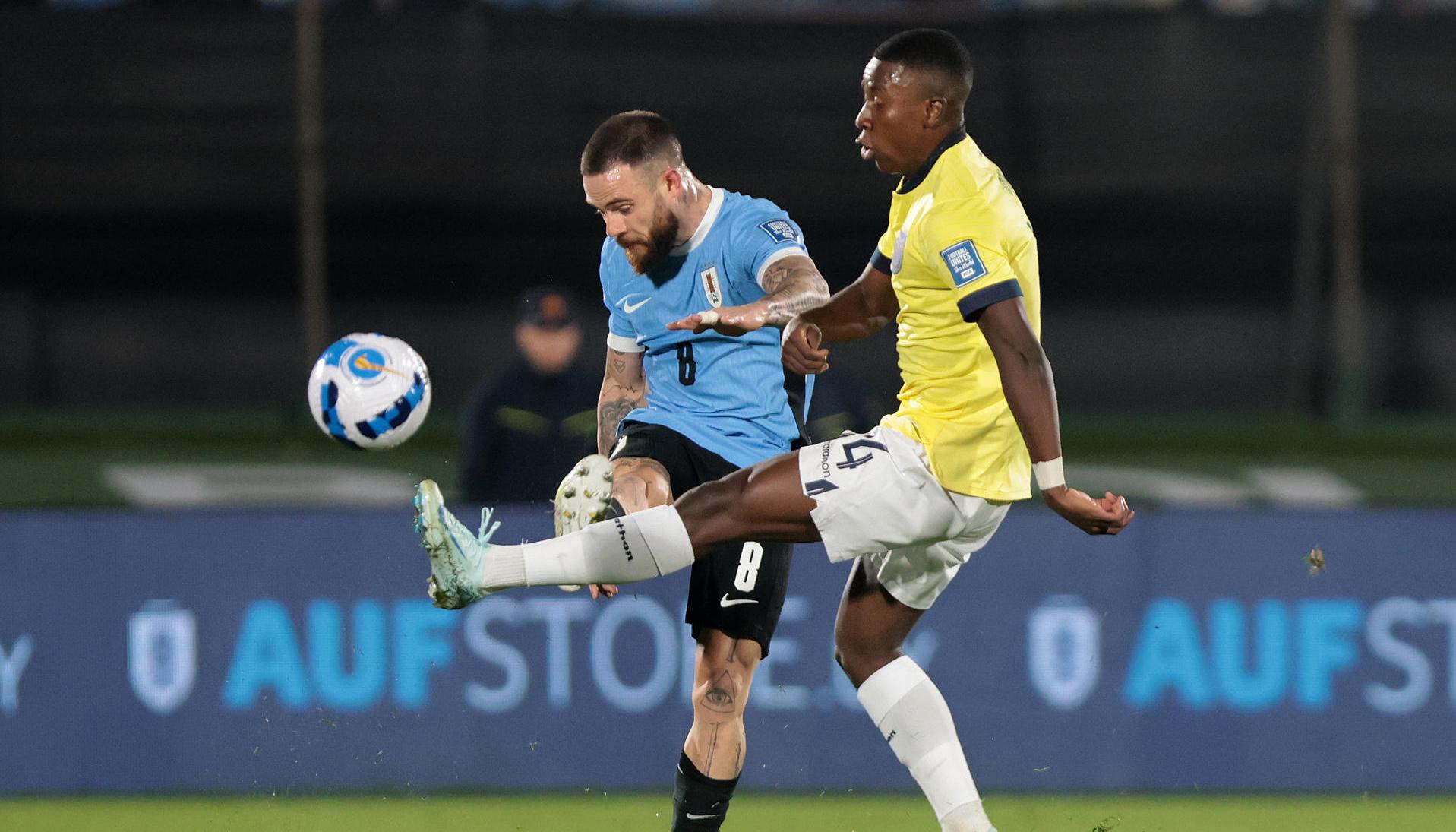 Nahitan Nández, de Uruguay, disputa un balón con Alan Minda, de Ecuador.