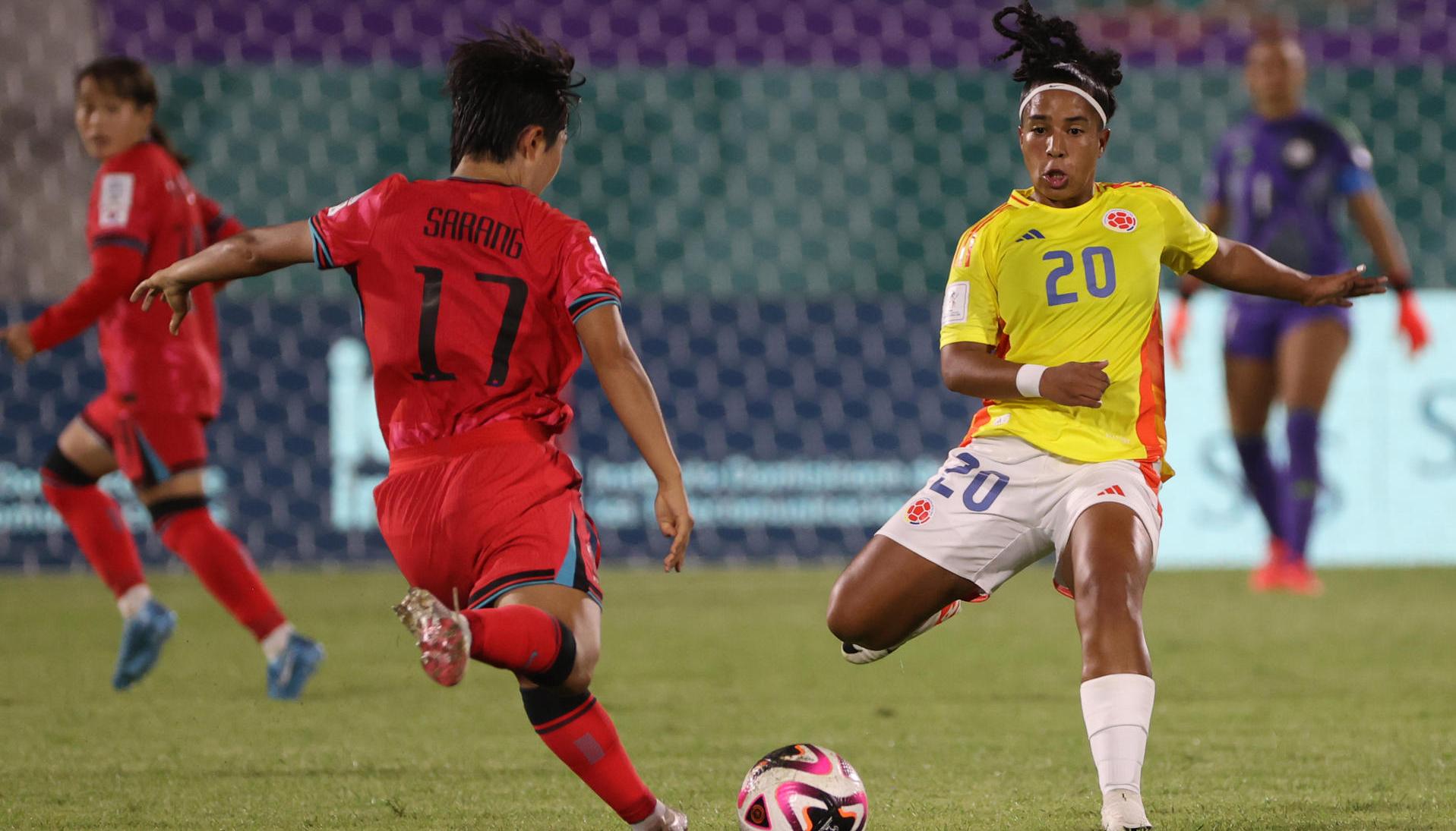 Nam Sarang, de Corea del Sur, disputa el balón con Reina Torres.