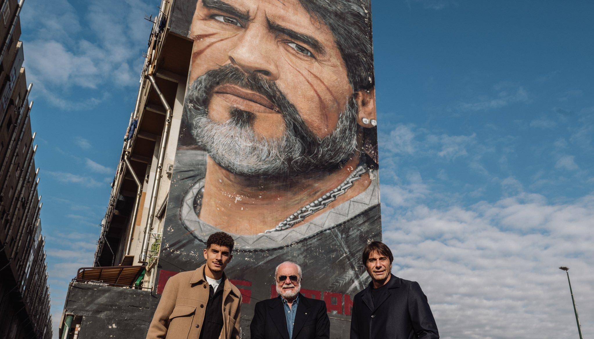 Giovanni Di Lorenzo, capitán del Nápoles, el presidente Aurelio De Laurentiis y el técnico Antonio Conte junto a un mural de Maradona.