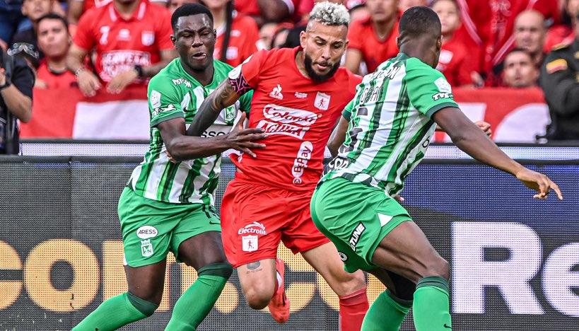 Duván Vergara busca abrirse paso entre dos jugadores de Nacional. 