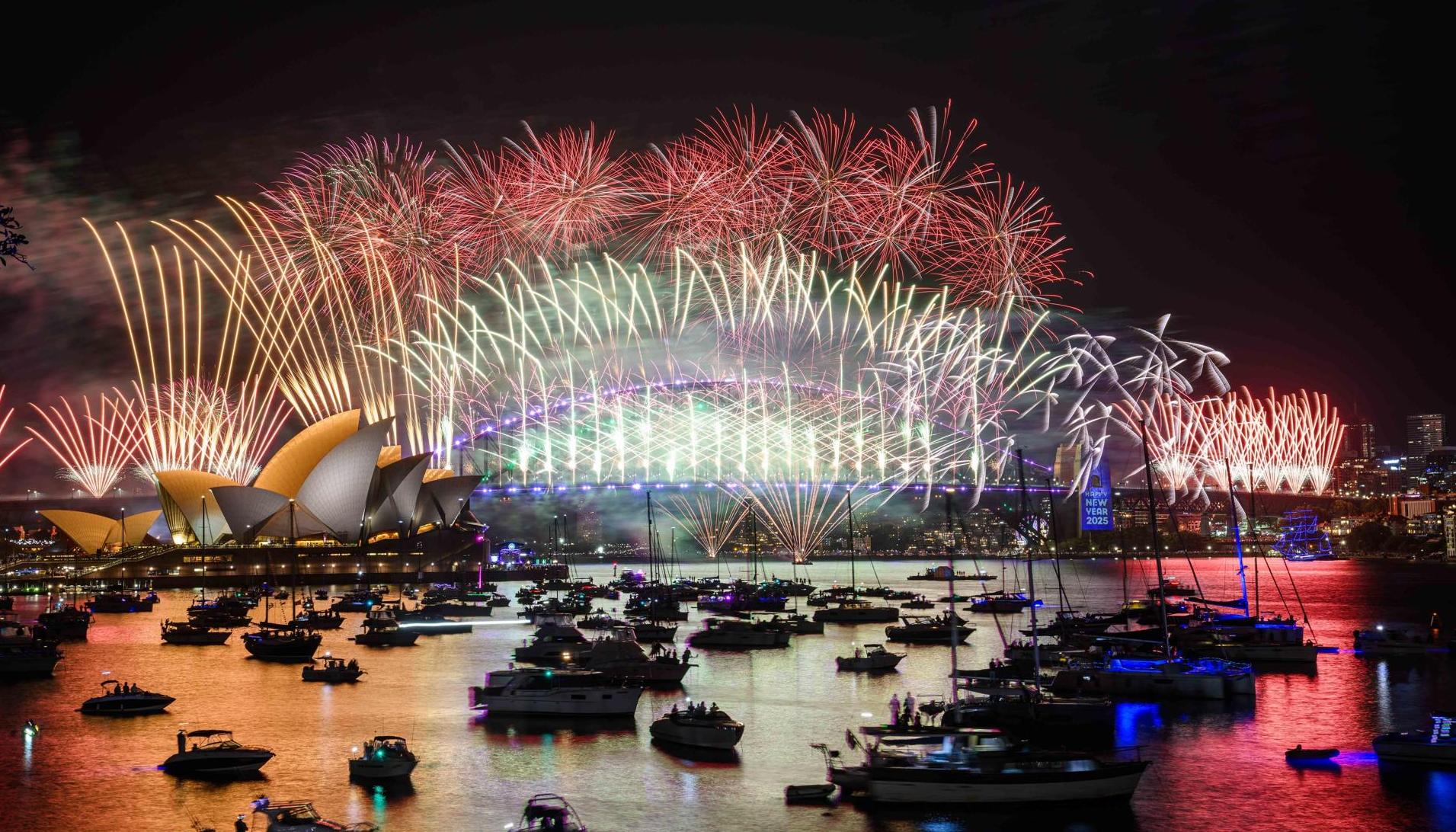 Fuegos artificiales iluminan el cielo sobre la Ópera de Sídney y el Puente del Puerto como parte de las primeras celebraciones.