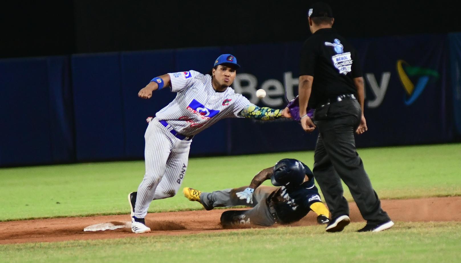 Michael Arroyo, de Caimanes, no logra impedir el robo de base del corredor de Leones.